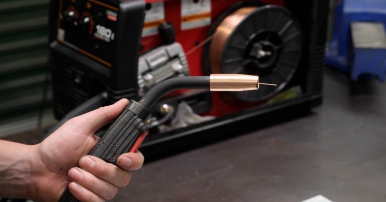 MIG welding torch in a motorsport workshop