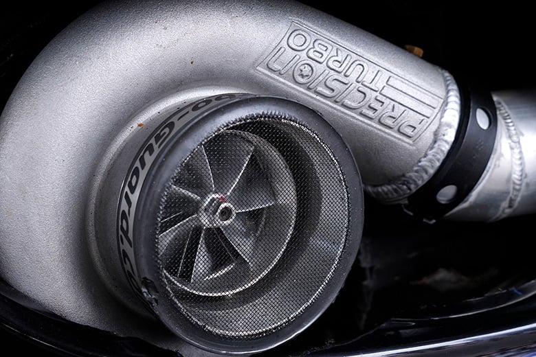 Precision turbocharger with debris shield on a performance diesel engine