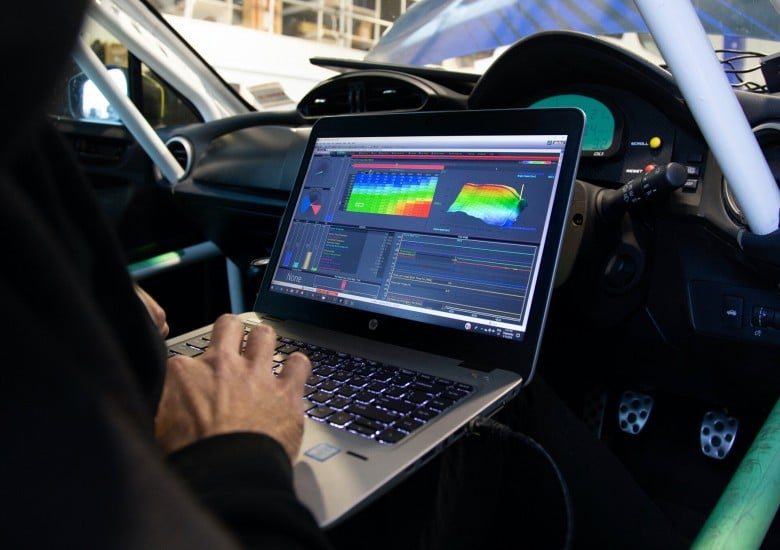 2B0A75A4 C5F9 4CF9 A52D 88DAD9313902 driver seated in a CAN bus equipped race car being tuned via laptop