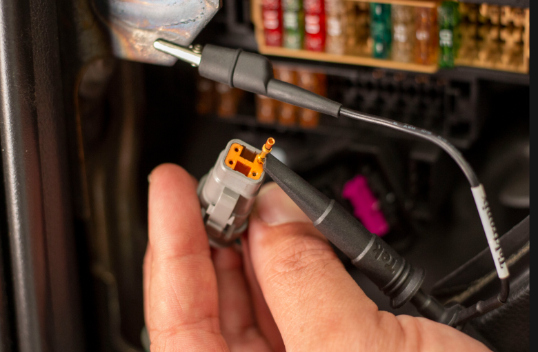 Holding a DTM connector showing the pin mating through the wedge lock