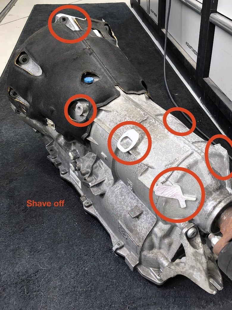 ZF 8HP transmission case with surplus tabs and casting features marked for trimming.