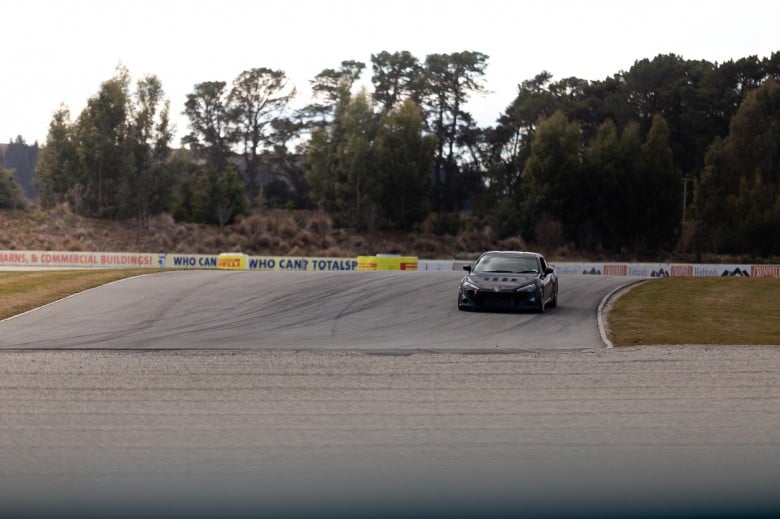 Performance car being driven at a racetrack during a track tuning session